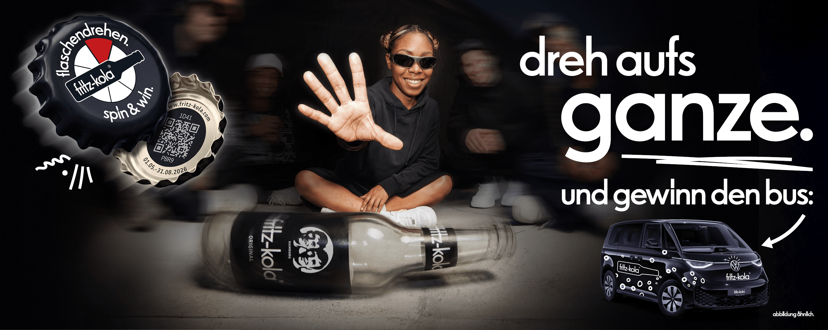 Werbe-Banner von fritz-kola: Eine junge Frau mit Sonnenbrille sitzt lachend auf dem Boden und hält eine Hand mit gespreizten Fingern hoch. Vor ihr liegen zwei fritz-kola-Flaschen. Links ist ein Kronkorken mit der Aufschrift „flaschendrehen. spin & win“. und einem QR-Code zu sehen. Rechts der Slogan „dreh aufs ganze. und gewinn den bus:“ mit einem abgebildeten schwarzen VW-Bus im fritz-kola-Design.